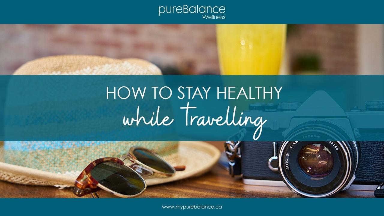 camera, sunglasses and hat on cafe table - How To Stay Healthy While Travelling - Article by pureBalance Wellness Cancer Care