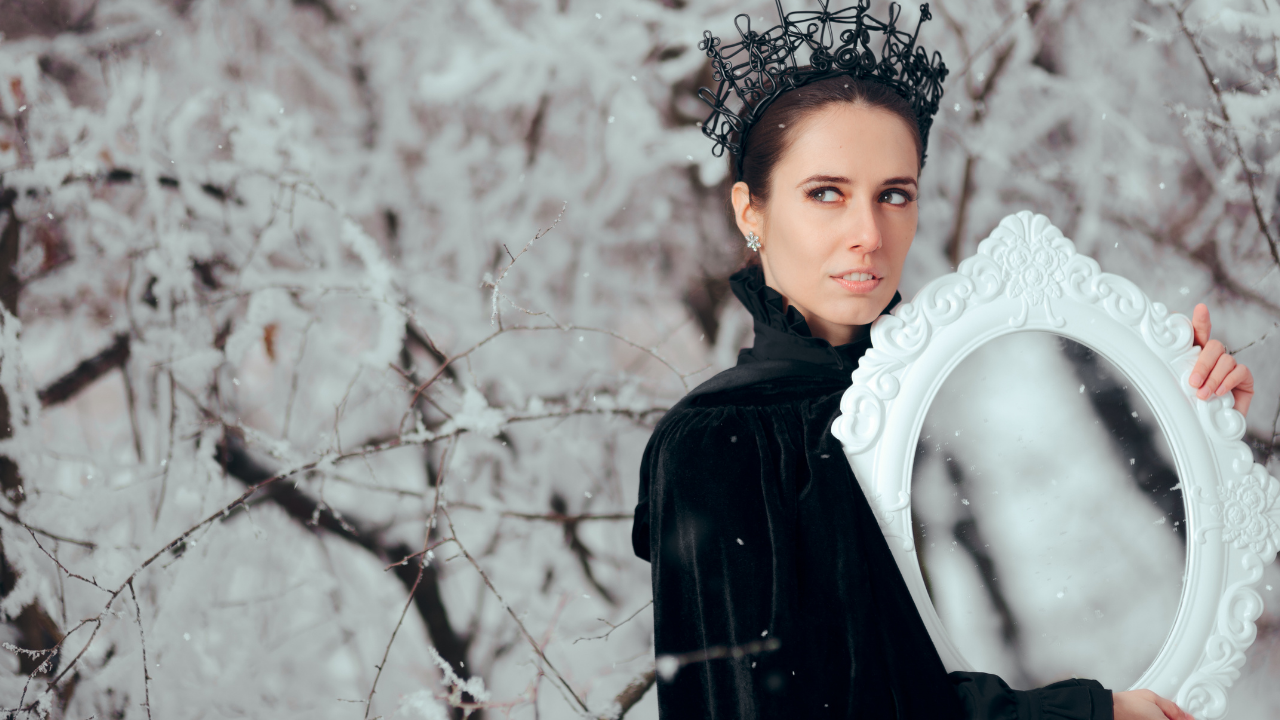 Queen or Witch holding a mirror in the snowy forest - holding the mirror of truth and freedom as she's not afraid to see herself and her shadow
