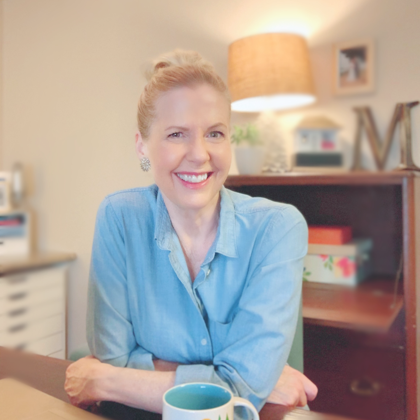 Woman sitting at a desk smiling. Lori Massicot.