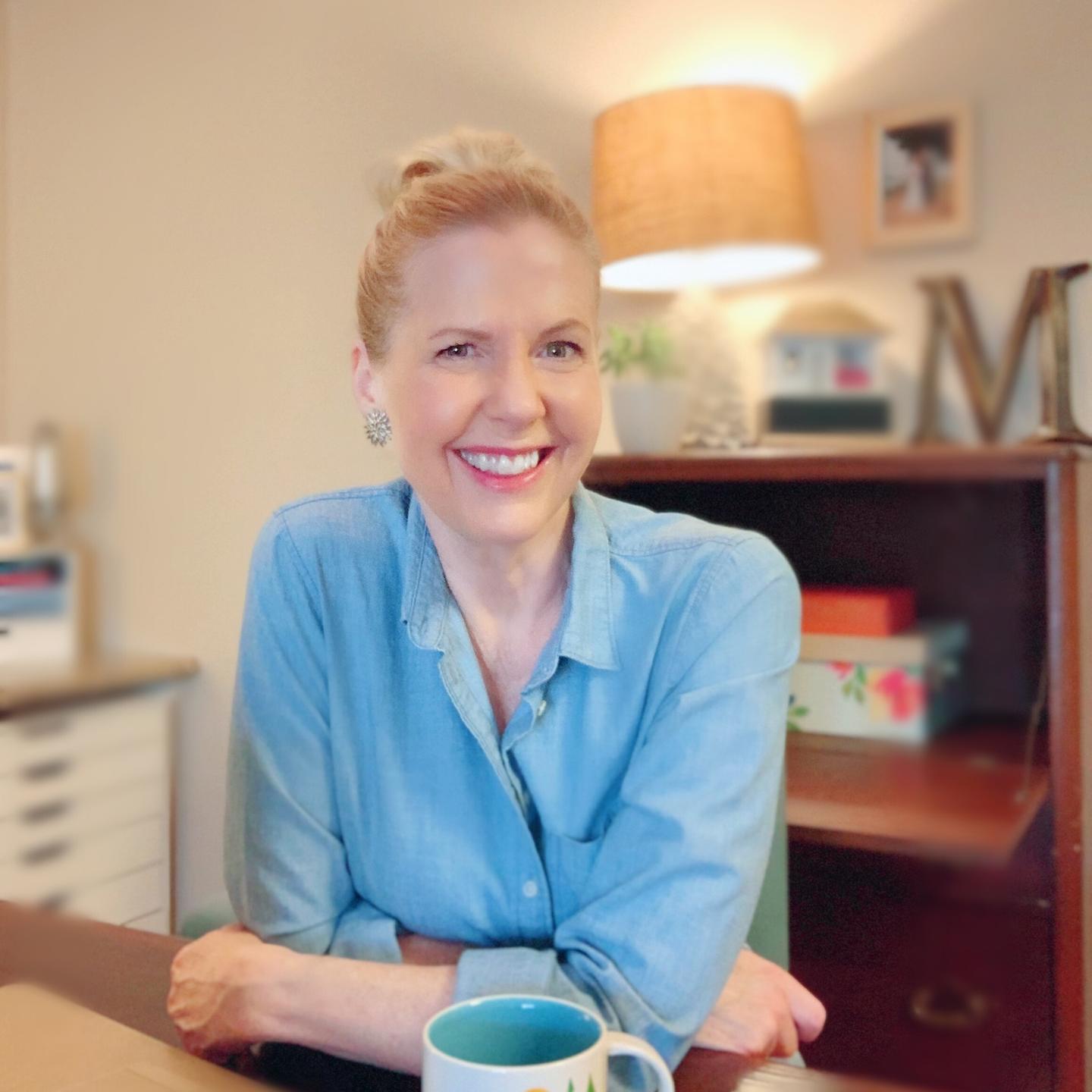 Lori Massicot sitting at a table smiling.