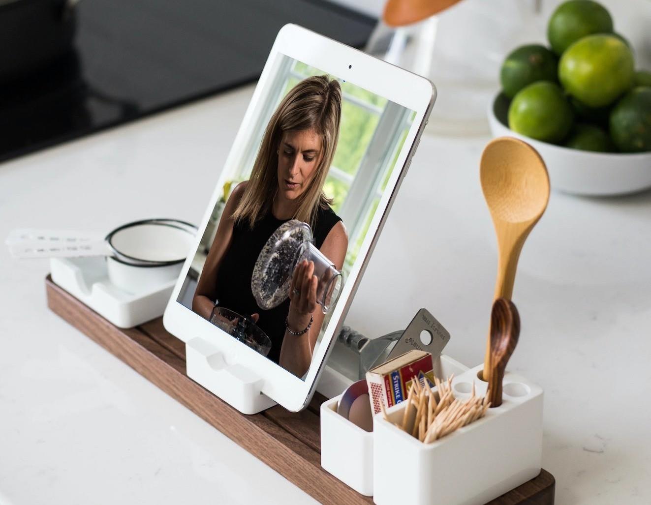 Ipad on stand in kitchen with image of Megan and a food processor on it