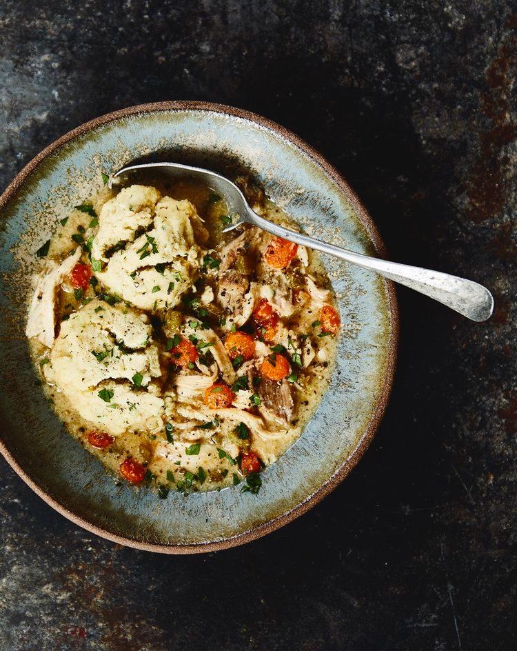 chicken dumplings in a bowl with a spoon coming out