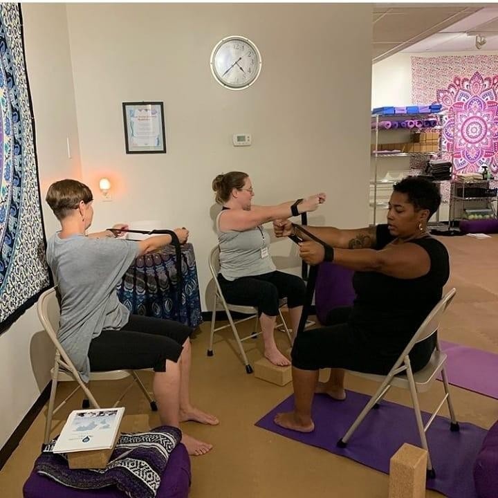 Photograph of 3 yoga teachers practicing together at the Accessible Yoga Training Intensive