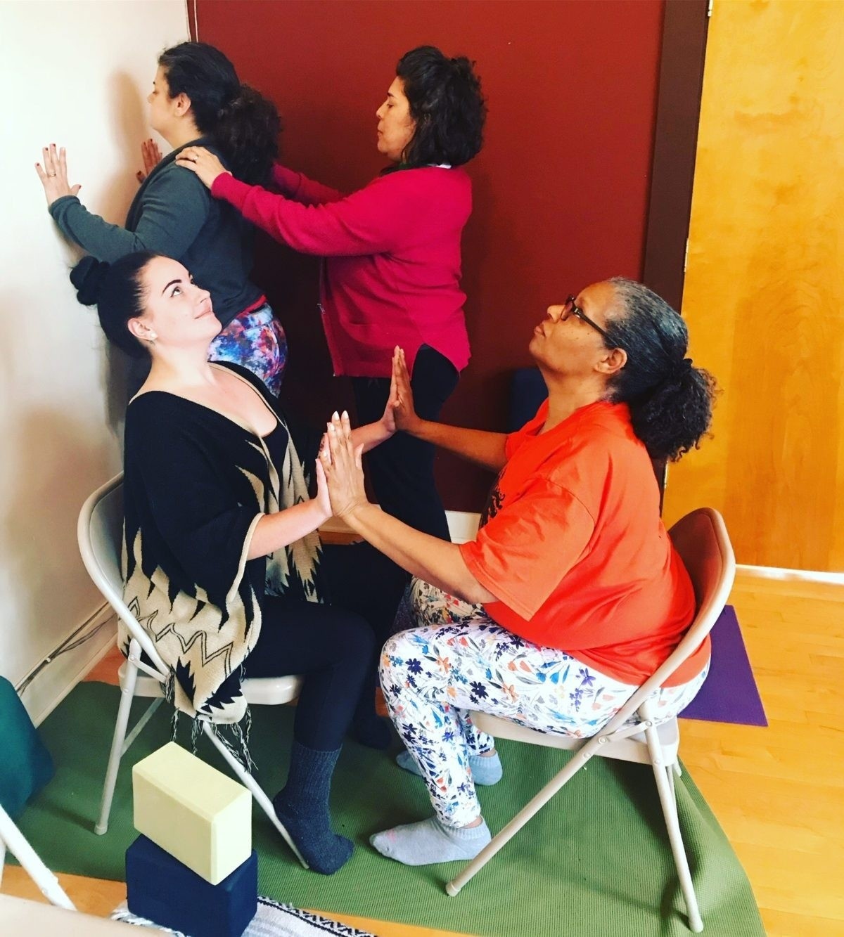 Photograph of 4 yoga teachers practicing together at the Accessible Yoga Training Intensive