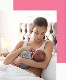 Mother Breastfeeding her Baby In Bed