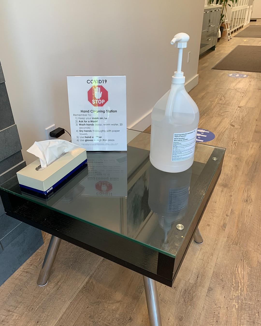 table with notice, kleenex and hand sanitizer