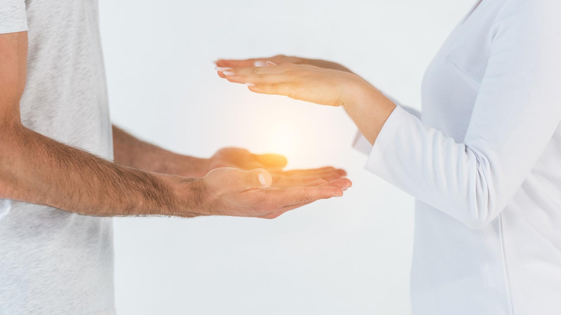 female hands hovering over male hands with energy in between - Energy Medicine Services available at pureBalance Wellness