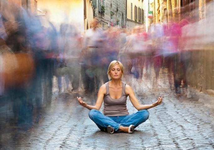 woman meditating crowded street