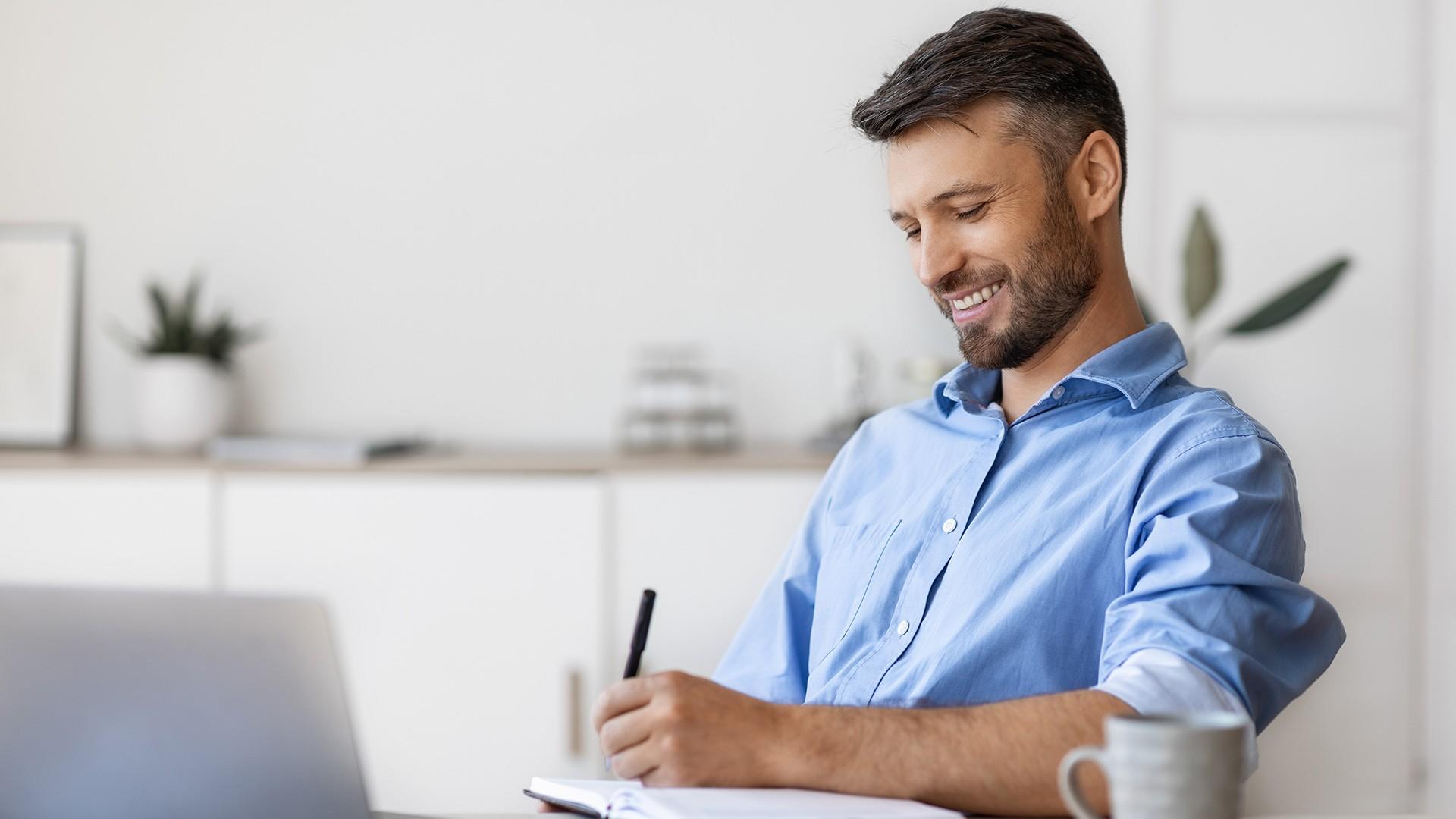 Happy Man at Desk writing in a journal