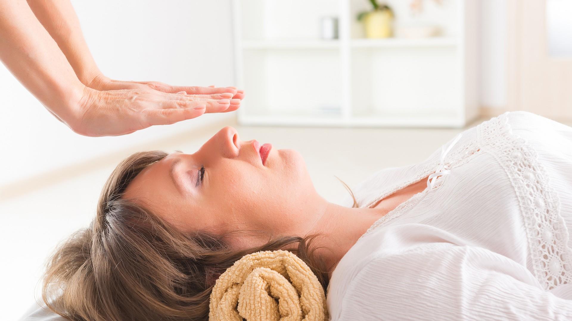 woman receiving reiki while lying down