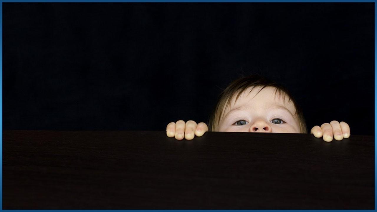 Child staring over a table