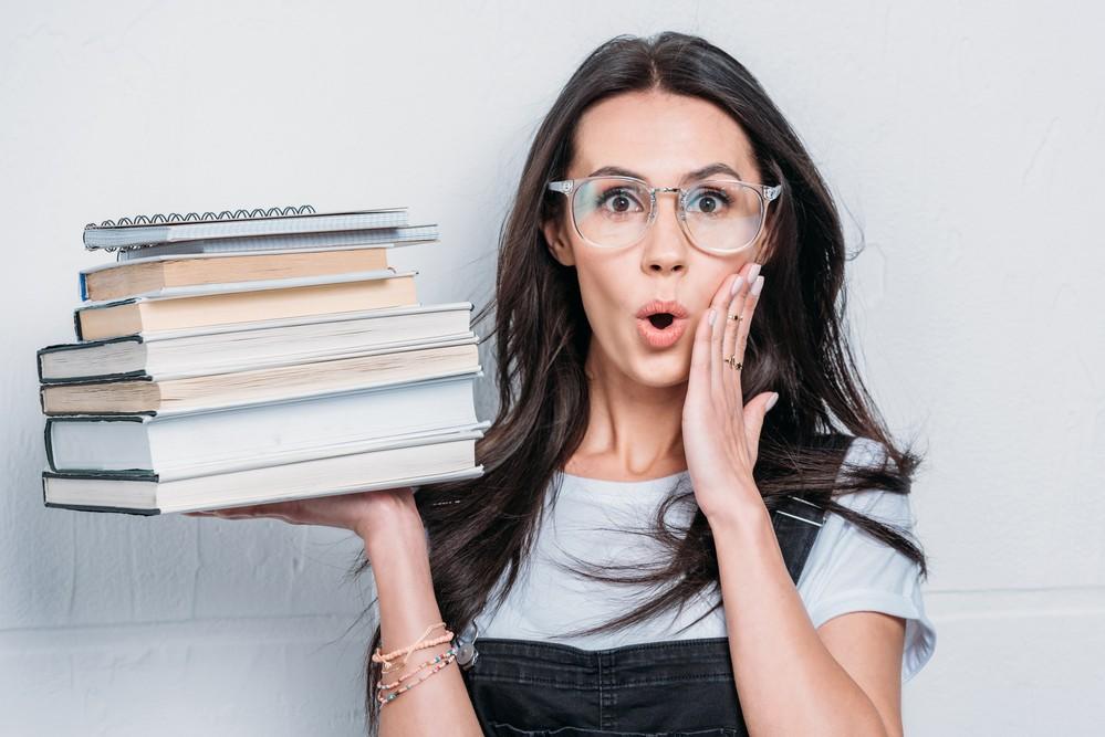 Girl Holding Pile of Profitable Books