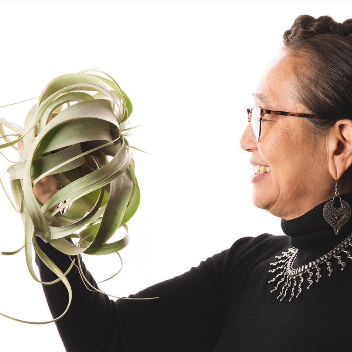 Hitomi Gilliam floral designer and educator smiling holding a succulence for Viva La Flora Live Podcast
