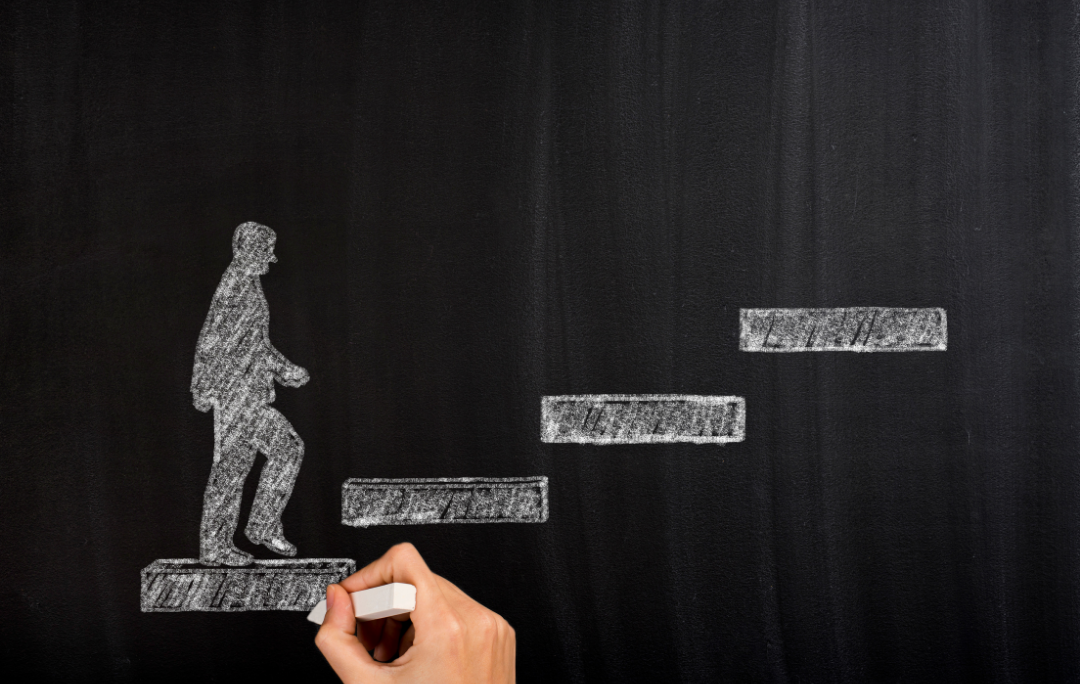 person walking up stairs drawn on chalkboard