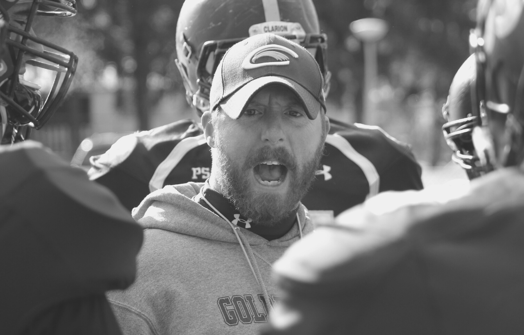 football coach surrounded by players