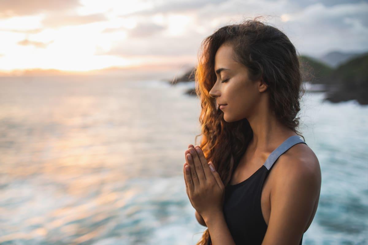 Woman meditating by sea