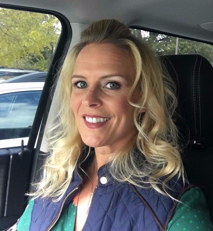 woman with long blonde hair with blue vest