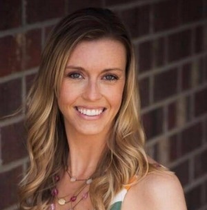 woman in tank top by brick wall