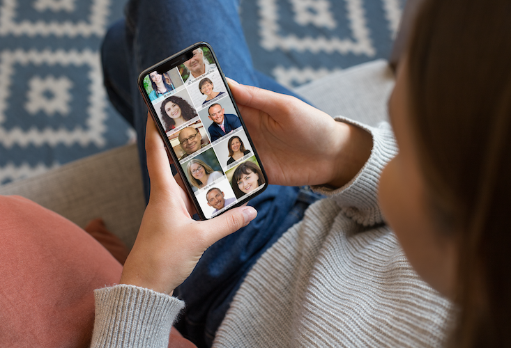 woman holding iPhone on couch