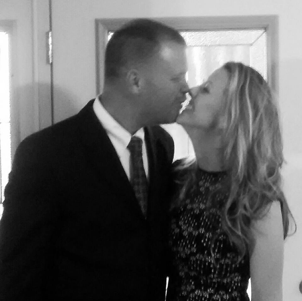 husband and wife kissing near door