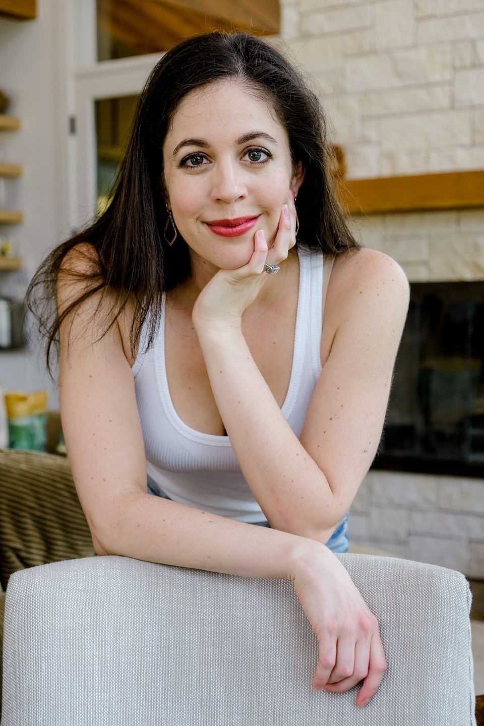 Rachel Loewenherz leans on a chair, chin in hands, with a warm smile—welcoming new entrepreneurs who want to take an idea and turn it into a business that empowers them with the tools to sustain themselves long-term